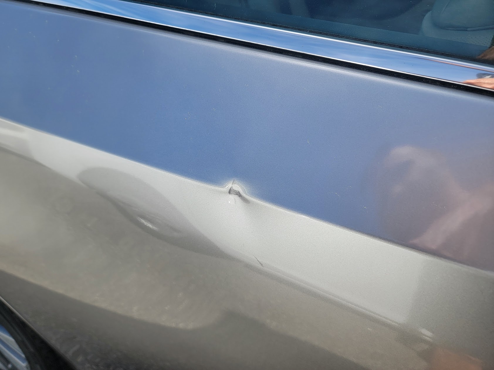Close-up of small door ding on silver paint